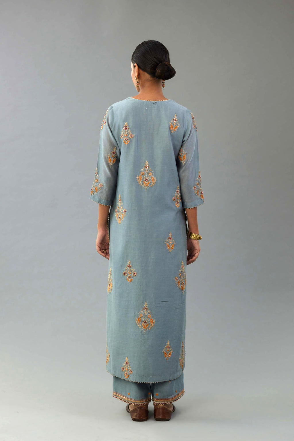 Light blue silk chanderi straight kurta set with zari, dori and contrast silk thread embroidered bootas, highlighted with gold sequins work.