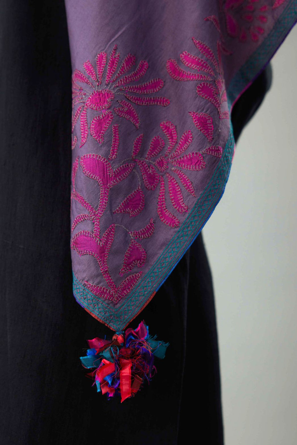 Grey silk square scarf with silk fabric applique work and embroidery at edges.