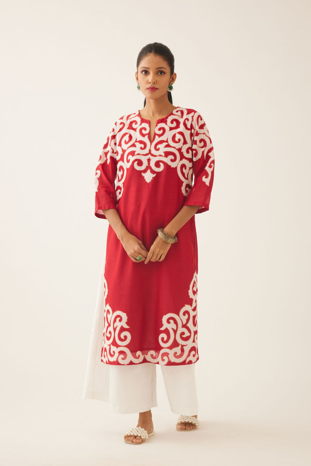 Red straight kurta with cotton appliqué, highlighted with kantha work, paired with off white cotton wide leg pants with side pockets.