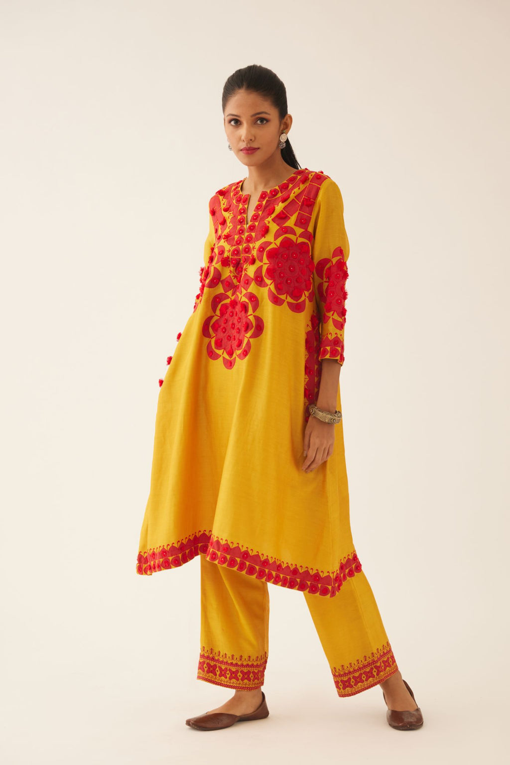 Golden yellow silk chanderi A-line kurta set, highlighted with contrast applique, tassels and sequins.