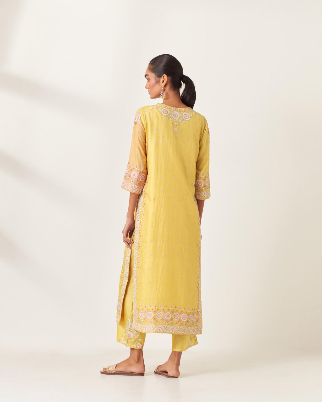 Yellow slim fit straight kurta set, decorated with bold appliqué borders all along the side seam, hem and sleeve cuffs.