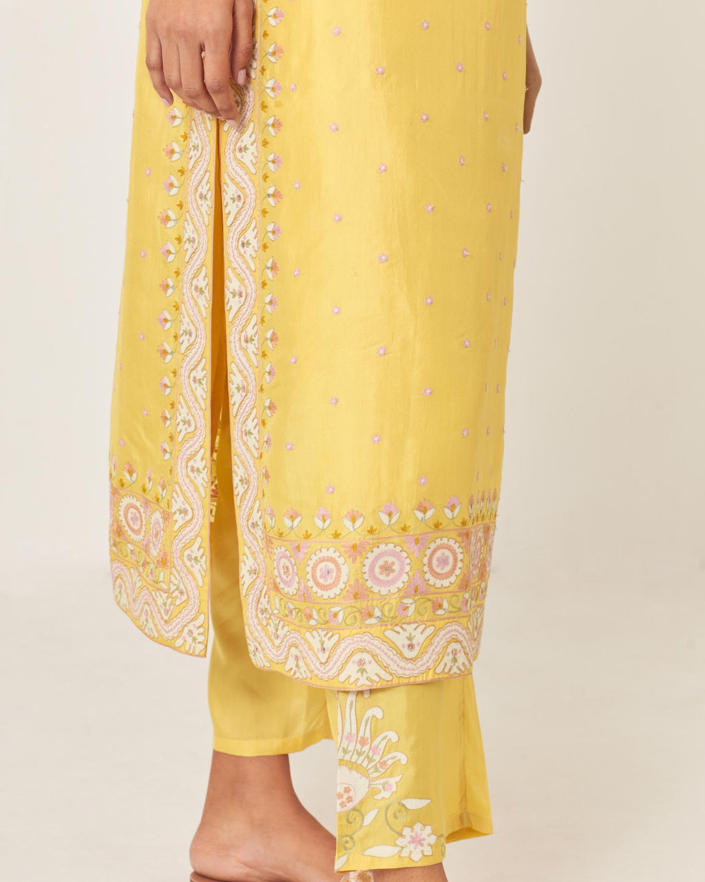 Yellow slim fit straight kurta set, decorated with bold appliqué borders all along the side seam, hem and sleeve cuffs.