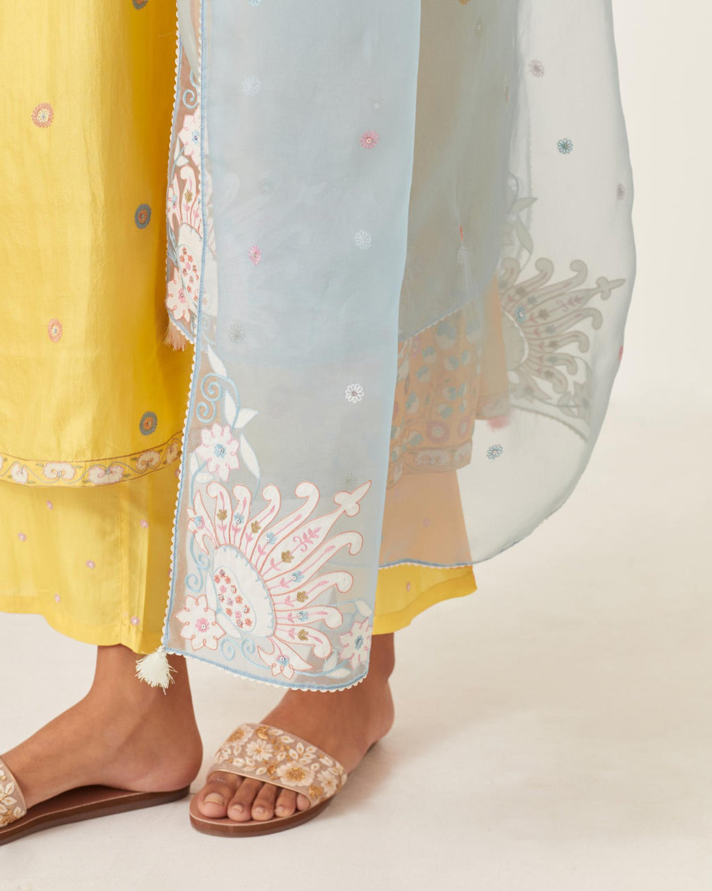 Yellow silk kurta dress set with appliqué stripes along with aari threadwork flowers and floral trellises along with a circular appliqued motif and fine gathers at empire line.