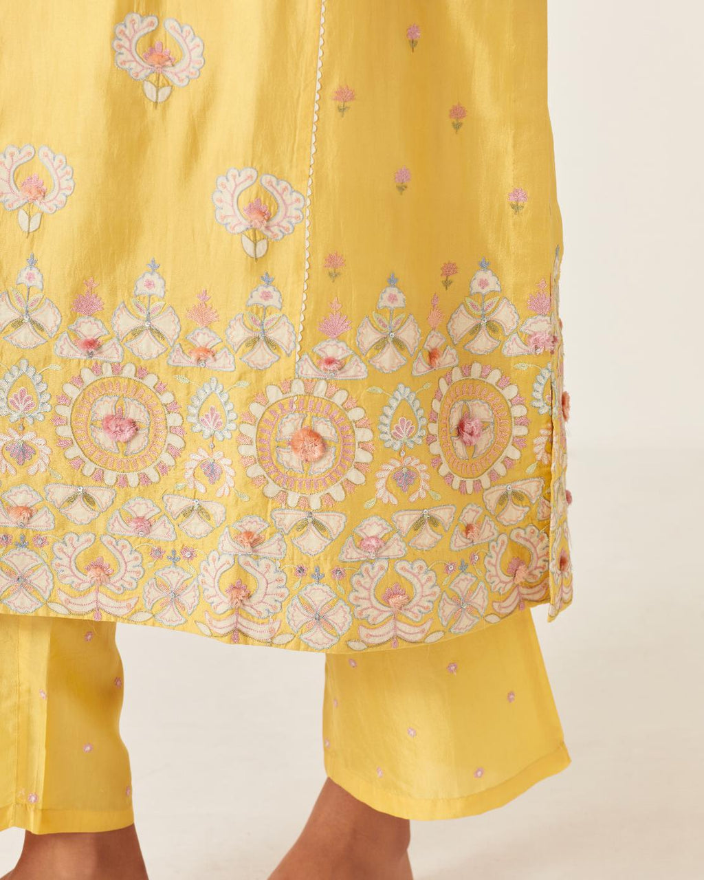 Yellow kalidar straight kurta set, fully embroidered with appliqué flowers, multi-colored aari threadwork and silk tassels.