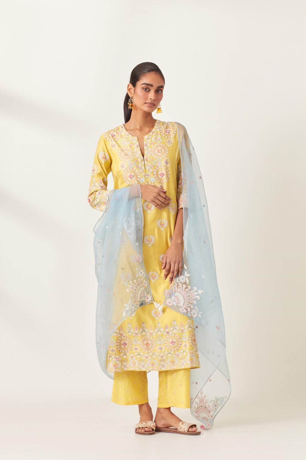 Yellow kalidar straight kurta set, fully embroidered with appliqué flowers, multi-colored aari threadwork and silk tassels.