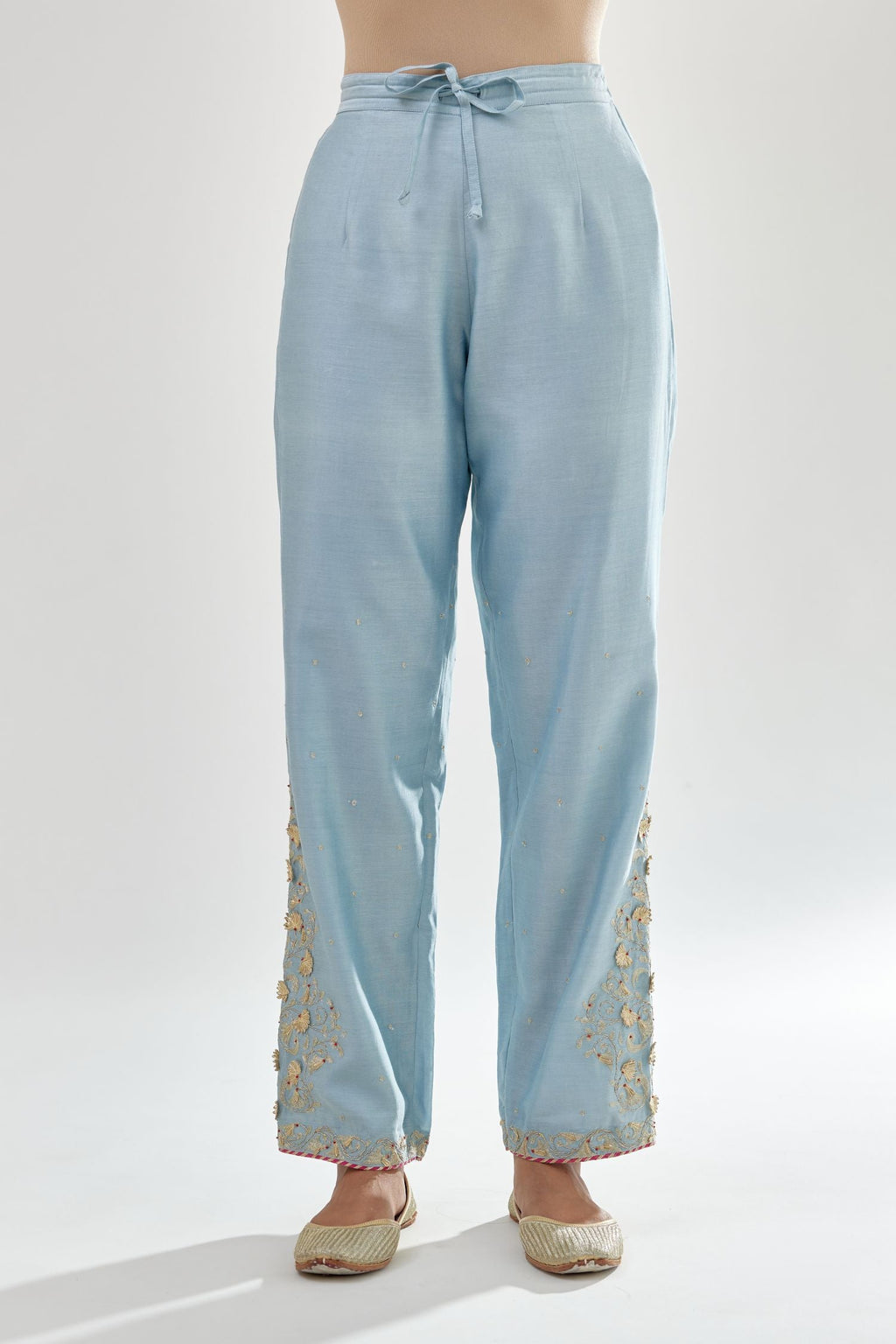 Blue silk chanderi straight pants, hem is detailed with zari, dori and gota embroidered boota at sides.
