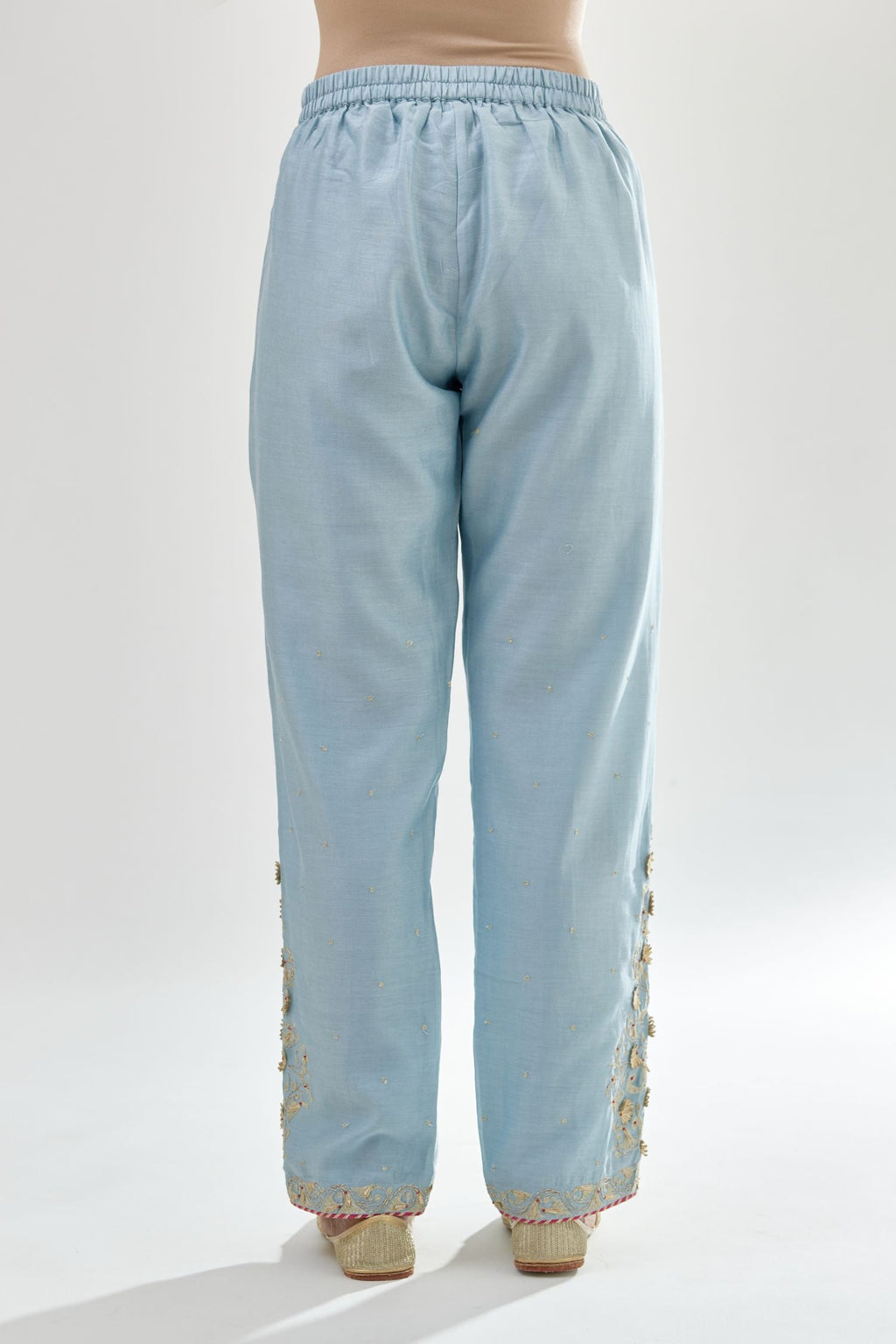 Blue silk chanderi straight pants, hem is detailed with zari, dori and gota embroidered boota at sides.