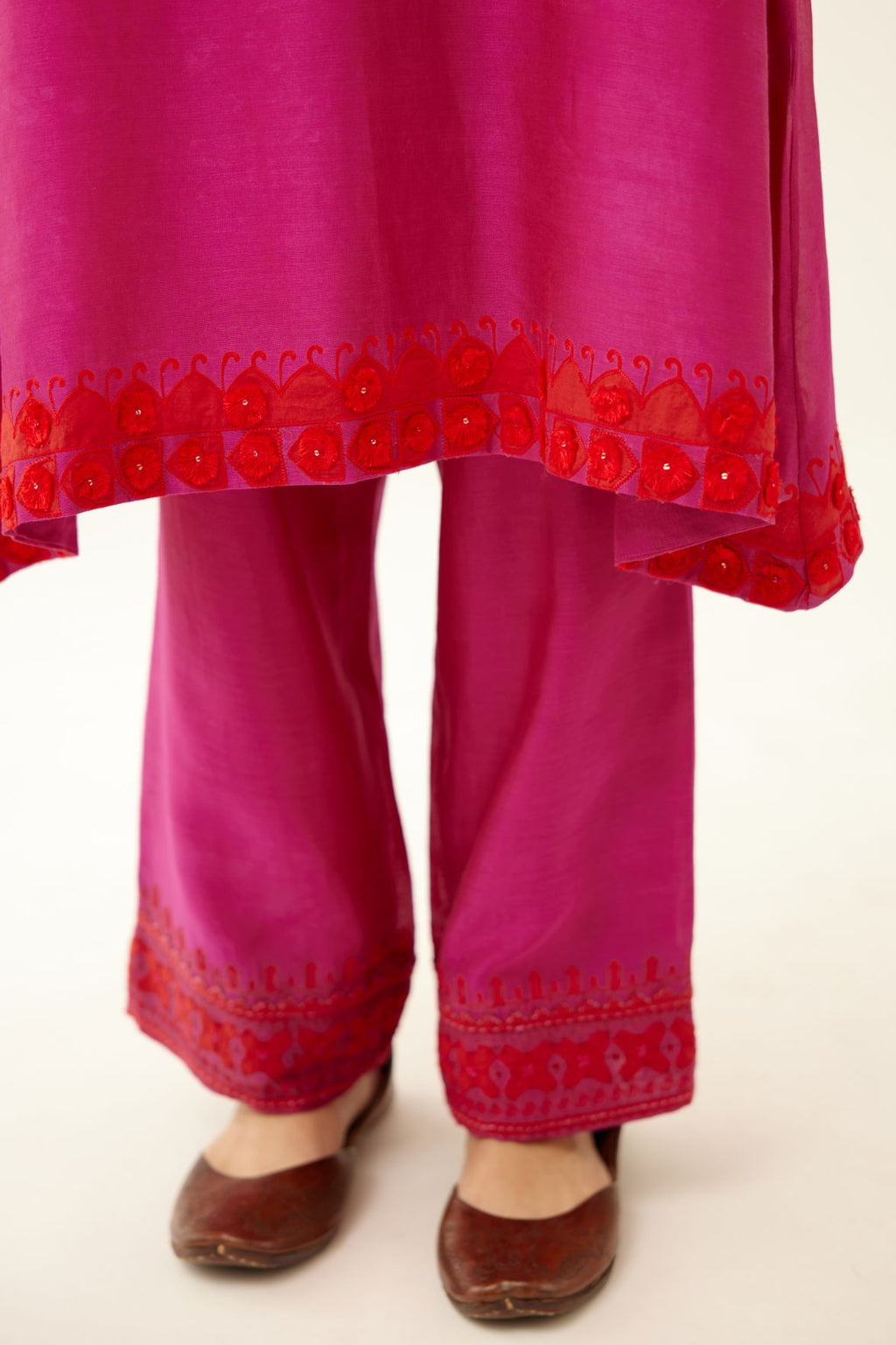Fuchsia silk chanderi A-line kurta set, highlighted with contrast applique, tassels and sequins.