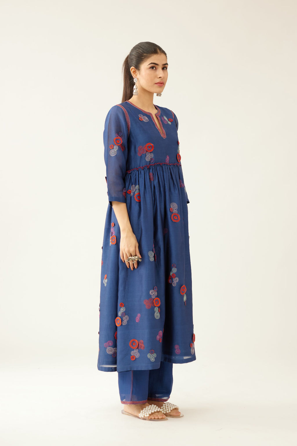 Blue silk chanderi long kurta set, highlighted with all-over multi colored 3D spiral embroidery and contrast over lock detail at empire waist.