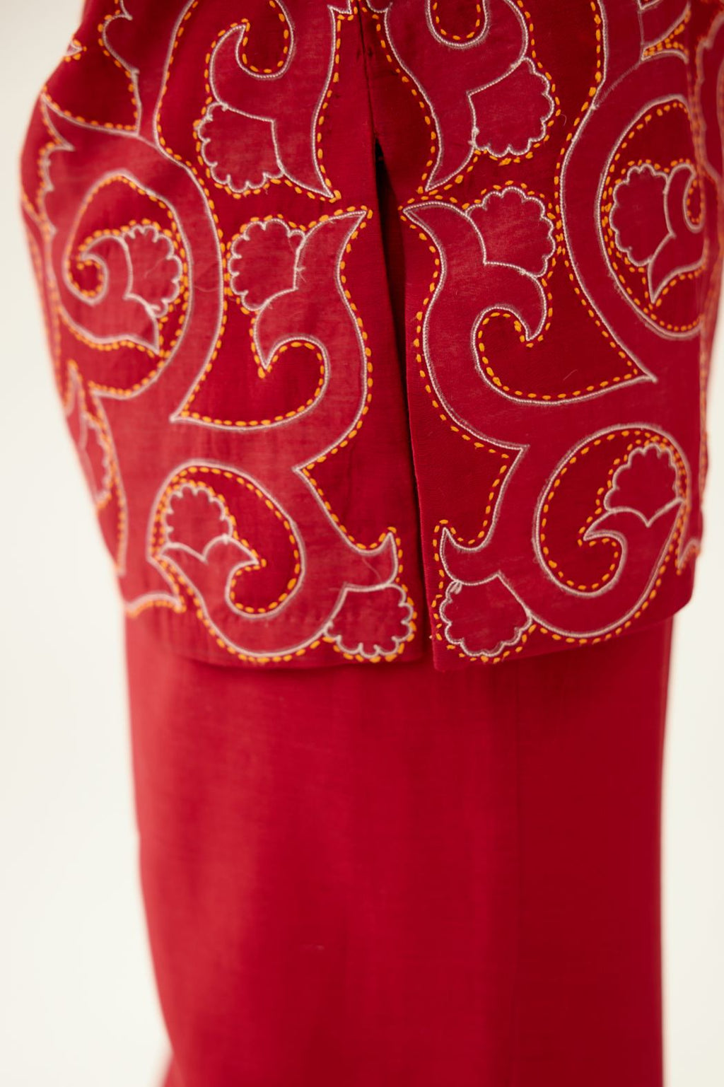 Red silk chanderi straight short kurta with all-over cotton appliqué jaal work, highlighted with kantha work, paired with red silk chanderi straight pants with cotton appliqué jaal work at bottom hem.