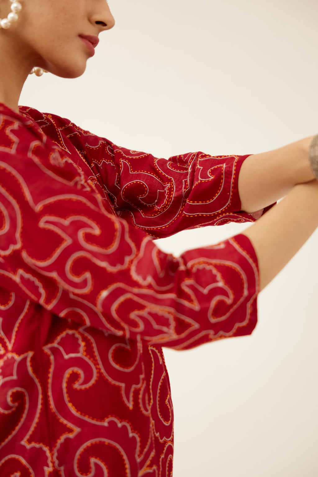 Red silk chanderi straight short kurta with all-over cotton appliqué jaal work, highlighted with kantha work, paired with red silk chanderi straight pants with cotton appliqué jaal work at bottom hem.