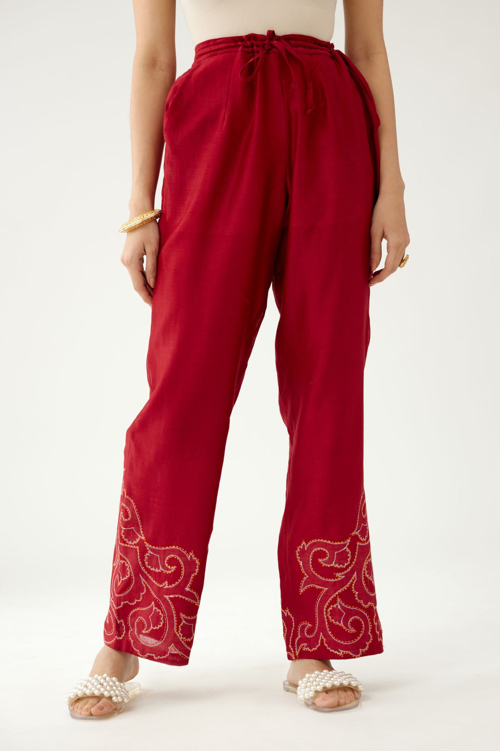 Red silk chanderi straight pants with cotton appliqué jaal work at reverse side, highlighted with kantha work in front side at bottom hem.