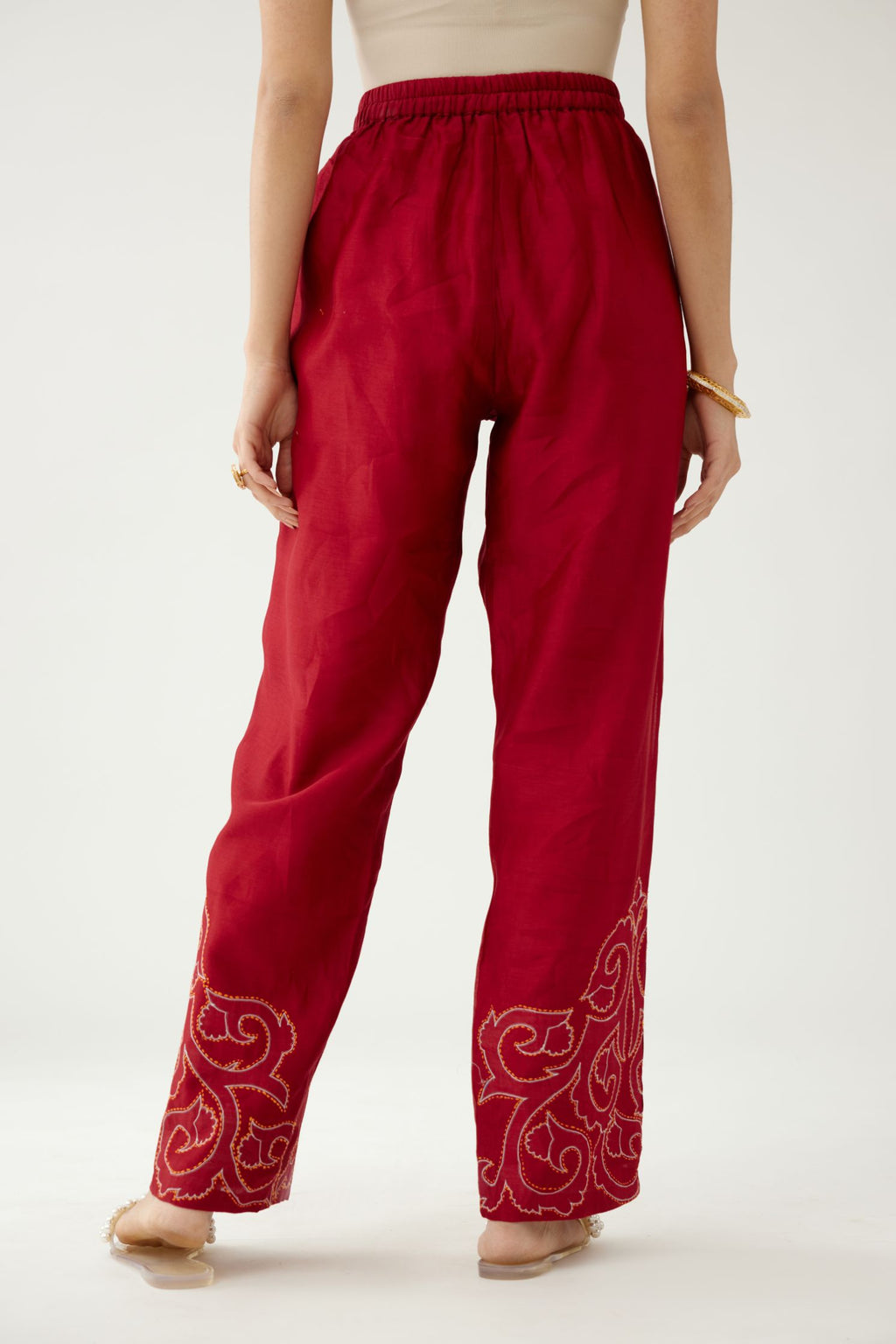Red silk chanderi straight pants with cotton appliqué jaal work at reverse side, highlighted with kantha work in front side at bottom hem.