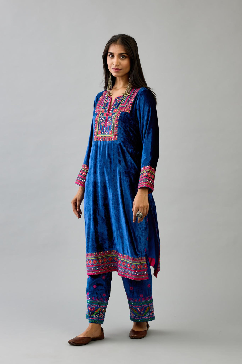 Blue silk velvet straight kurta set with yoke patchwork and silk thread embroidery highlighted with mirror, sequins, tassels and braids.