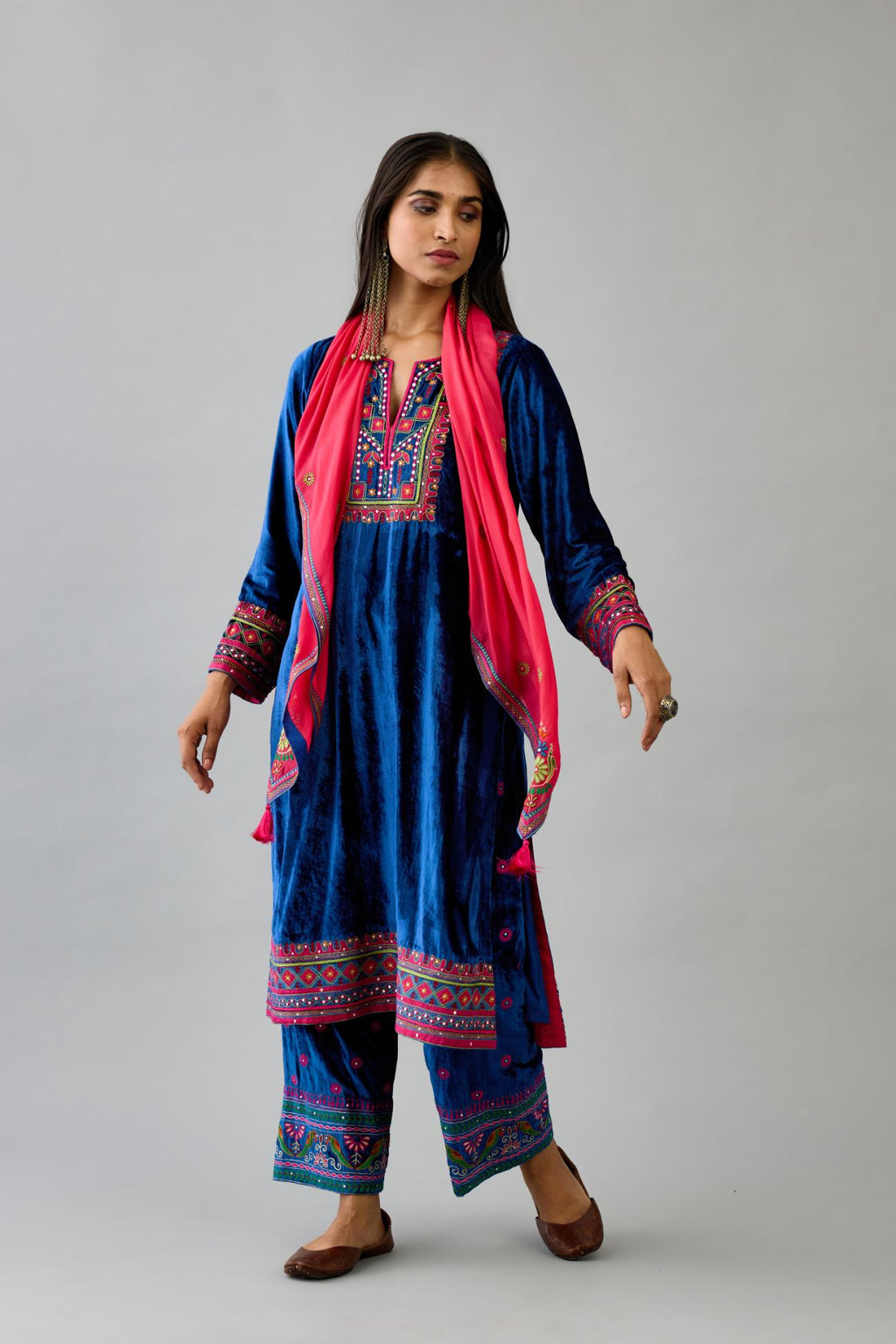 Blue silk velvet straight kurta set with yoke patchwork and silk thread embroidery highlighted with mirror, sequins, tassels and braids.
