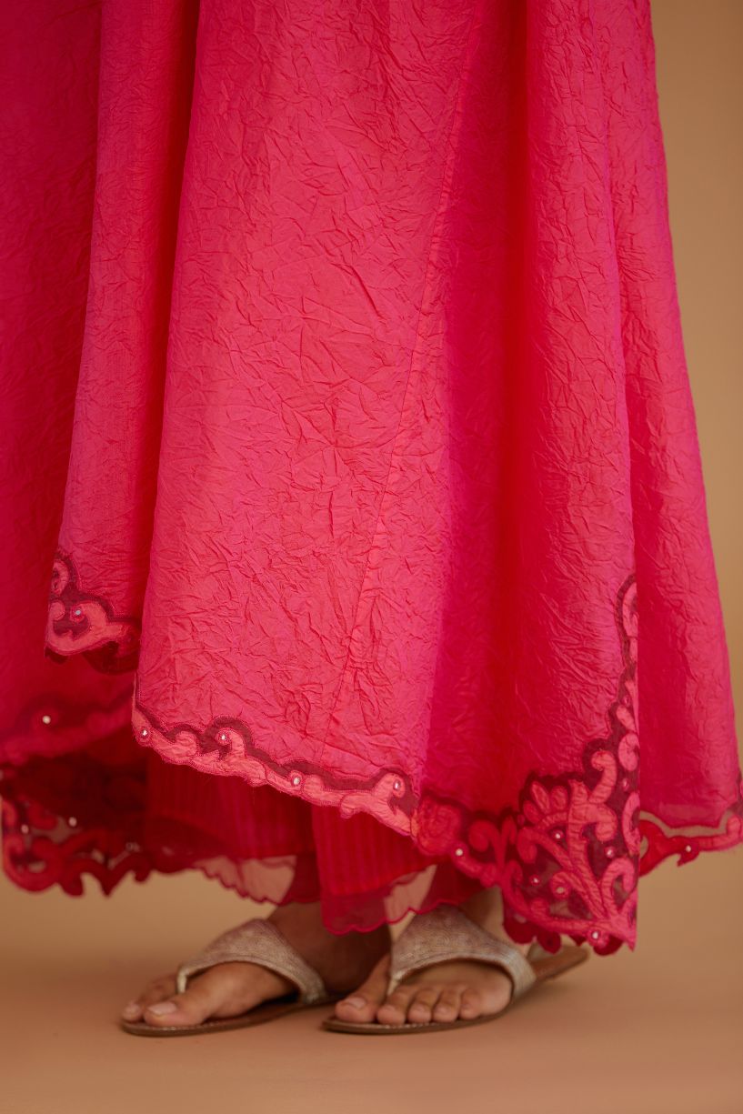 Fuchsia hand crushed silk kurta with cutwork embroidered asymmetric hem, highlighted with hand attached mirrors.