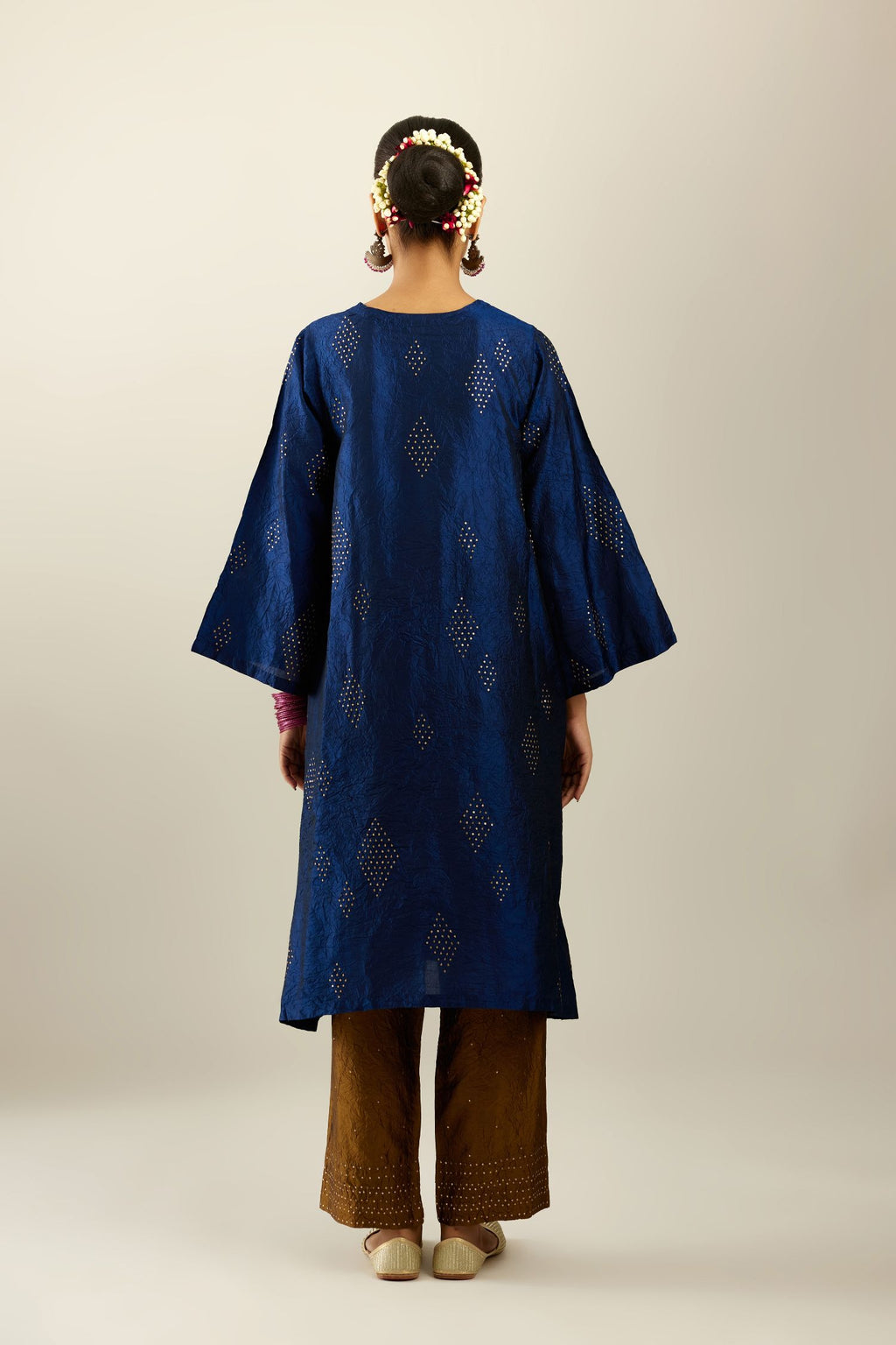 Navy blue silk hand crushed easy fit straight hem kurta, highlighted with all-over gold sequins in diamond shape, paired with golden olive hand crushed pure silk straight pants with gold sequins at hem in horizontal lines formation and side pockets.