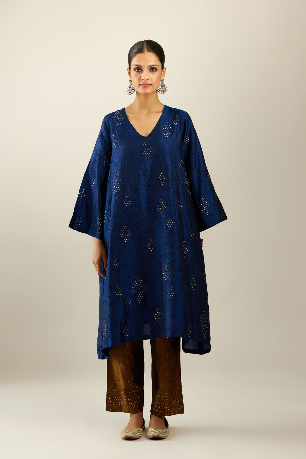Navy blue silk hand crushed easy fit straight hem kurta, highlighted with all-over gold sequins in diamond shape, paired with golden olive hand crushed pure silk straight pants with gold sequins at hem in horizontal lines formation and side pockets.