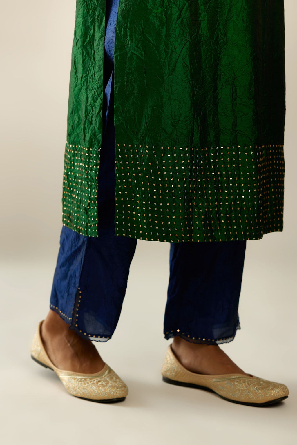 Dark green silk hand crushed kurta set with concealed button placket neckline, highlighted with gold sequins.