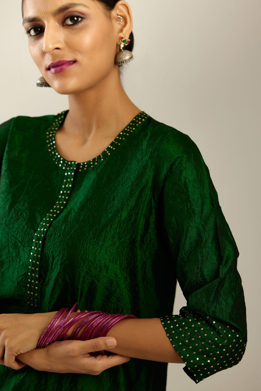 Dark green silk hand crushed kurta set with concealed button placket neckline, highlighted with gold sequins.