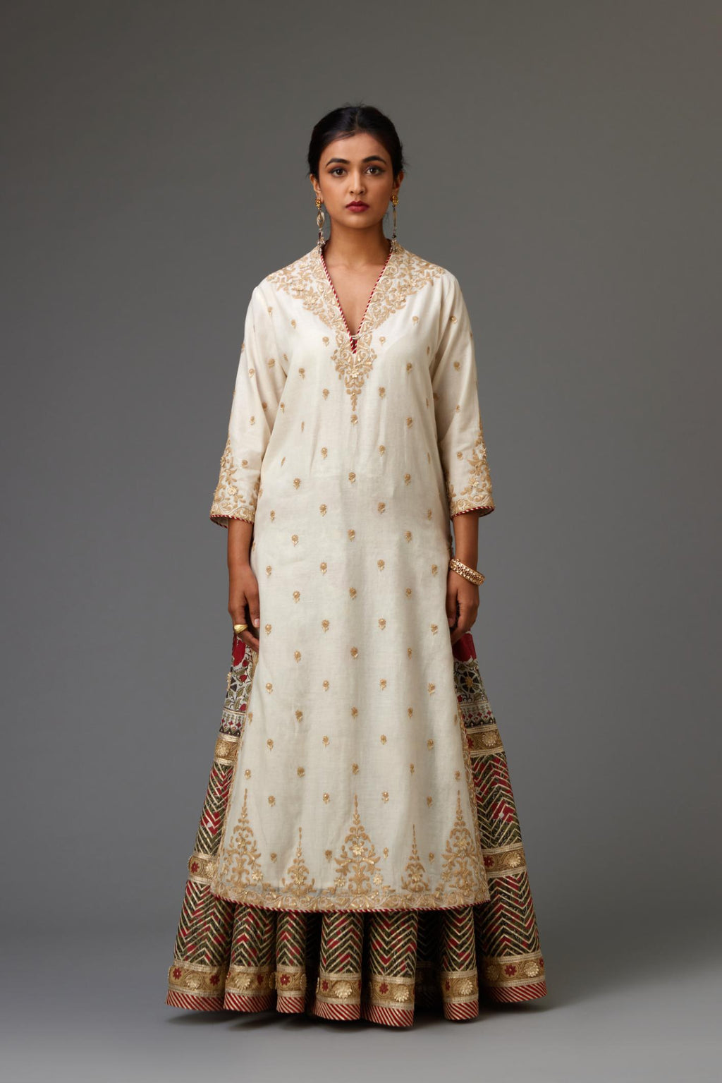 Off white cotton chanderi straight kurta with dori and gota embroidery, detailed with all-over delicate aari embroidery buties, paired with Silk chanderi hand block printed lehenga with herringbone gota embroidery at hem.