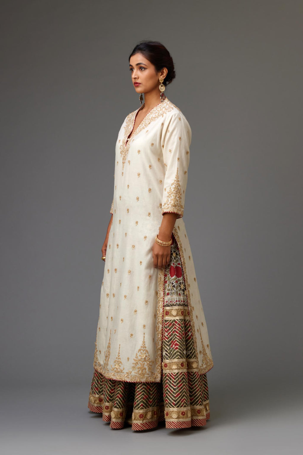 Off white cotton chanderi straight kurta with dori and gota embroidery, detailed with all-over delicate aari embroidery buties, paired with Silk chanderi hand block printed lehenga with herringbone gota embroidery at hem.