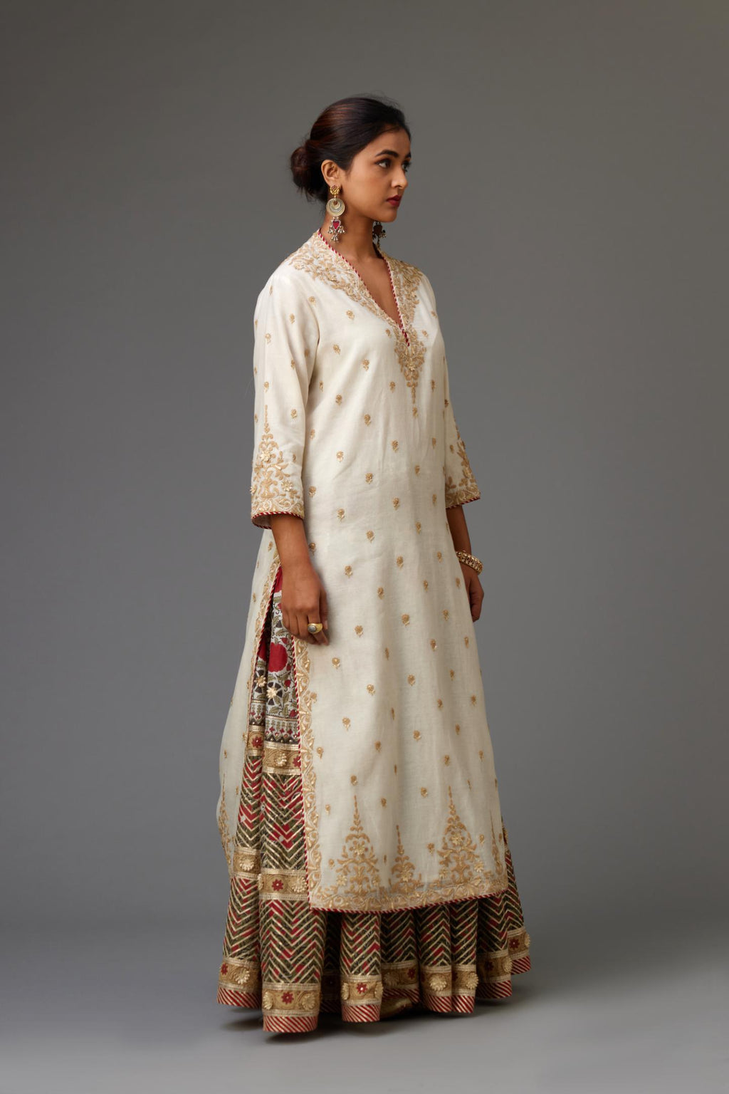 Off white cotton chanderi straight kurta with dori and gota embroidery, detailed with all-over delicate aari embroidery buties, paired with Silk chanderi hand block printed lehenga with herringbone gota embroidery at hem.