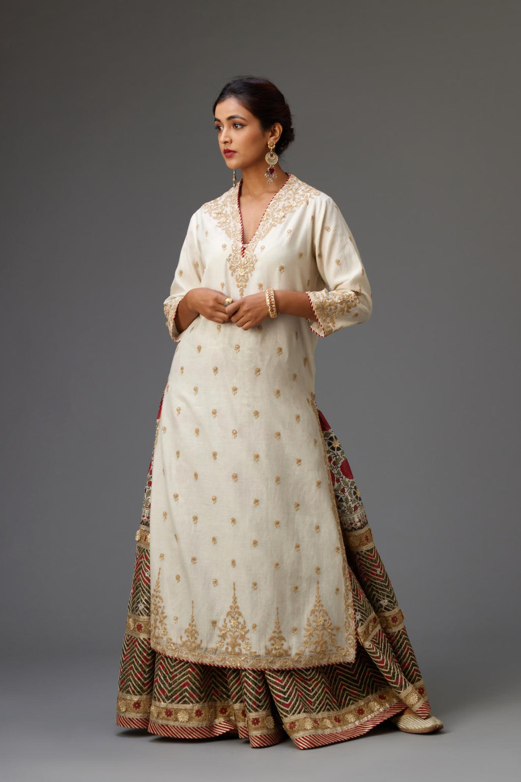 Off white cotton chanderi straight kurta with dori and gota embroidery, detailed with all-over delicate aari embroidery buties, paired with Silk chanderi hand block printed lehenga with herringbone gota embroidery at hem.