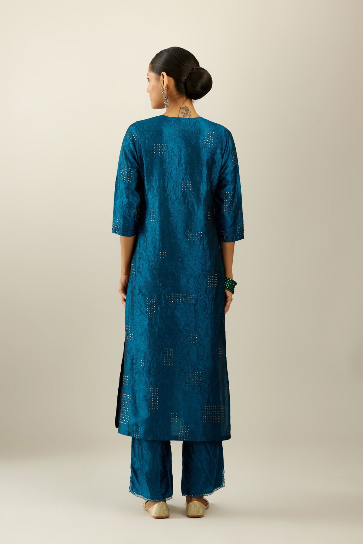 Dark teal hand crushed silk straight kurta, highlighted with all-over gold sequins rectangles, paired with  dark teal hand crushed silk straight pants with scalloped and embroidered organza at edges and detailed with a single line of sequins at hem