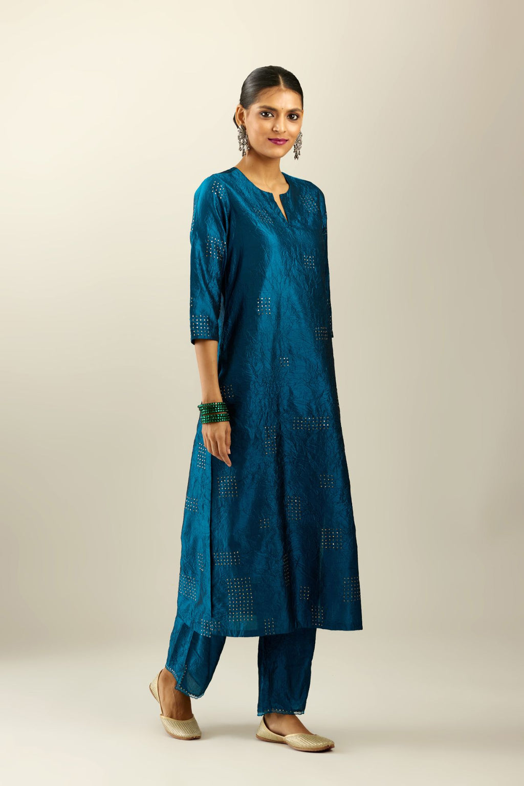 Dark teal hand crushed silk straight kurta, highlighted with all-over gold sequins rectangles, paired with  dark teal hand crushed silk straight pants with scalloped and embroidered organza at edges and detailed with a single line of sequins at hem