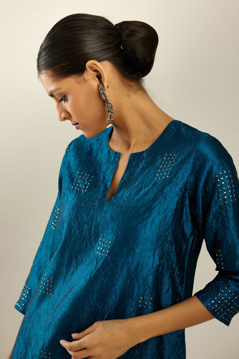 Dark teal hand crushed silk straight kurta, highlighted with all-over gold sequins rectangles, paired with  dark teal hand crushed silk straight pants with scalloped and embroidered organza at edges and detailed with a single line of sequins at hem