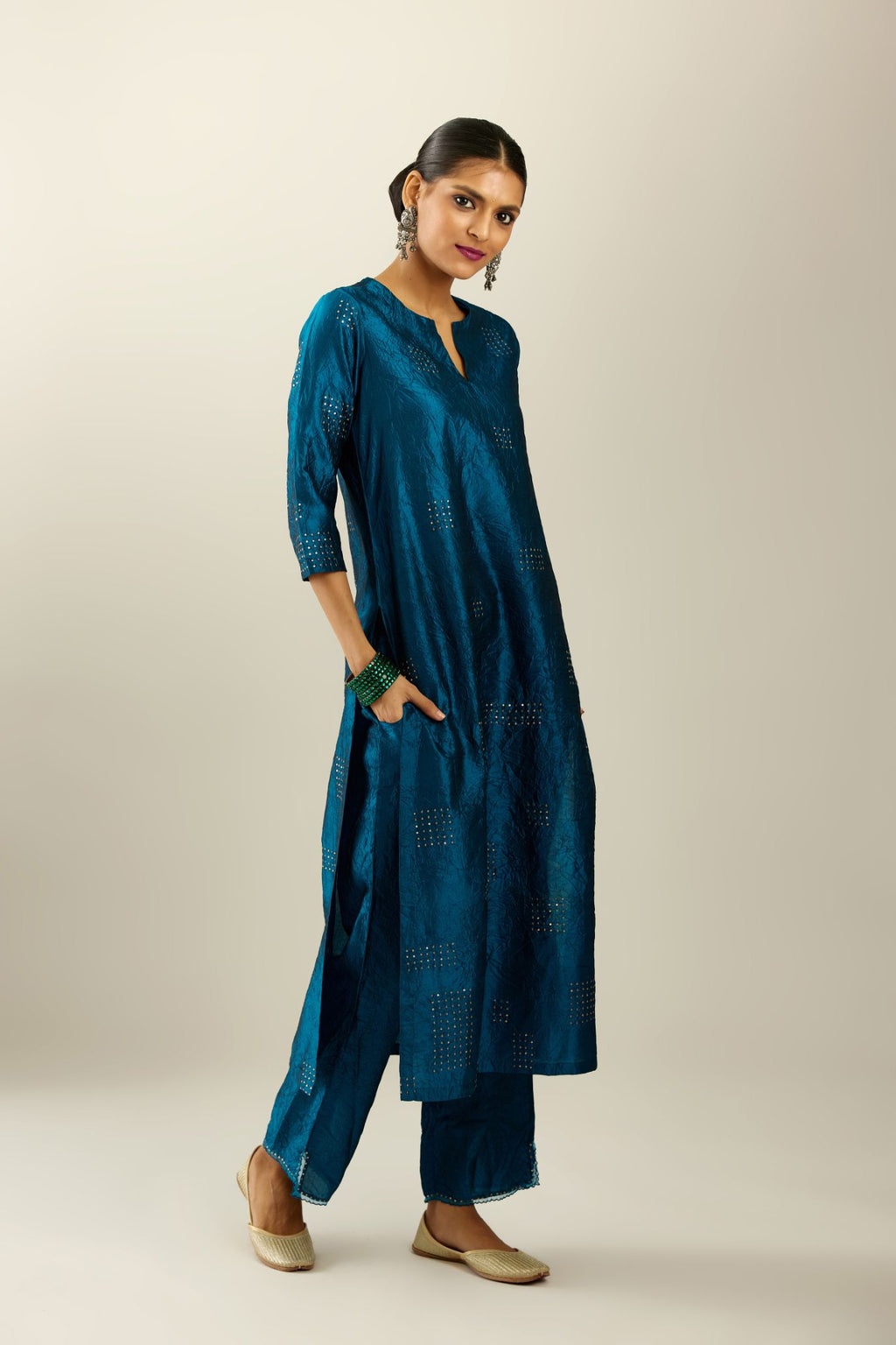 Dark teal hand crushed silk straight kurta, highlighted with all-over gold sequins rectangles, paired with  dark teal hand crushed silk straight pants with scalloped and embroidered organza at edges and detailed with a single line of sequins at hem