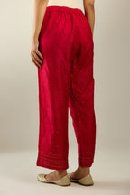 Red hand crushed pure silk straight pants with gold sequins at hem in horizontal lines formation and side pockets.