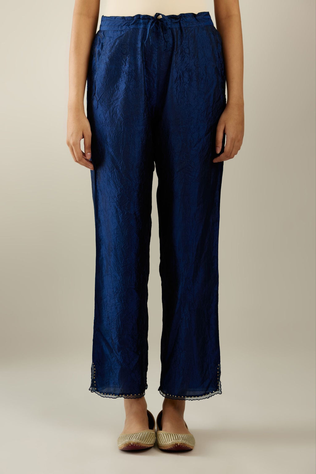 Navy blue hand crushed silk straight pants with scalloped and embroidered organza at edges and detailed with a single line of sequins at hem.