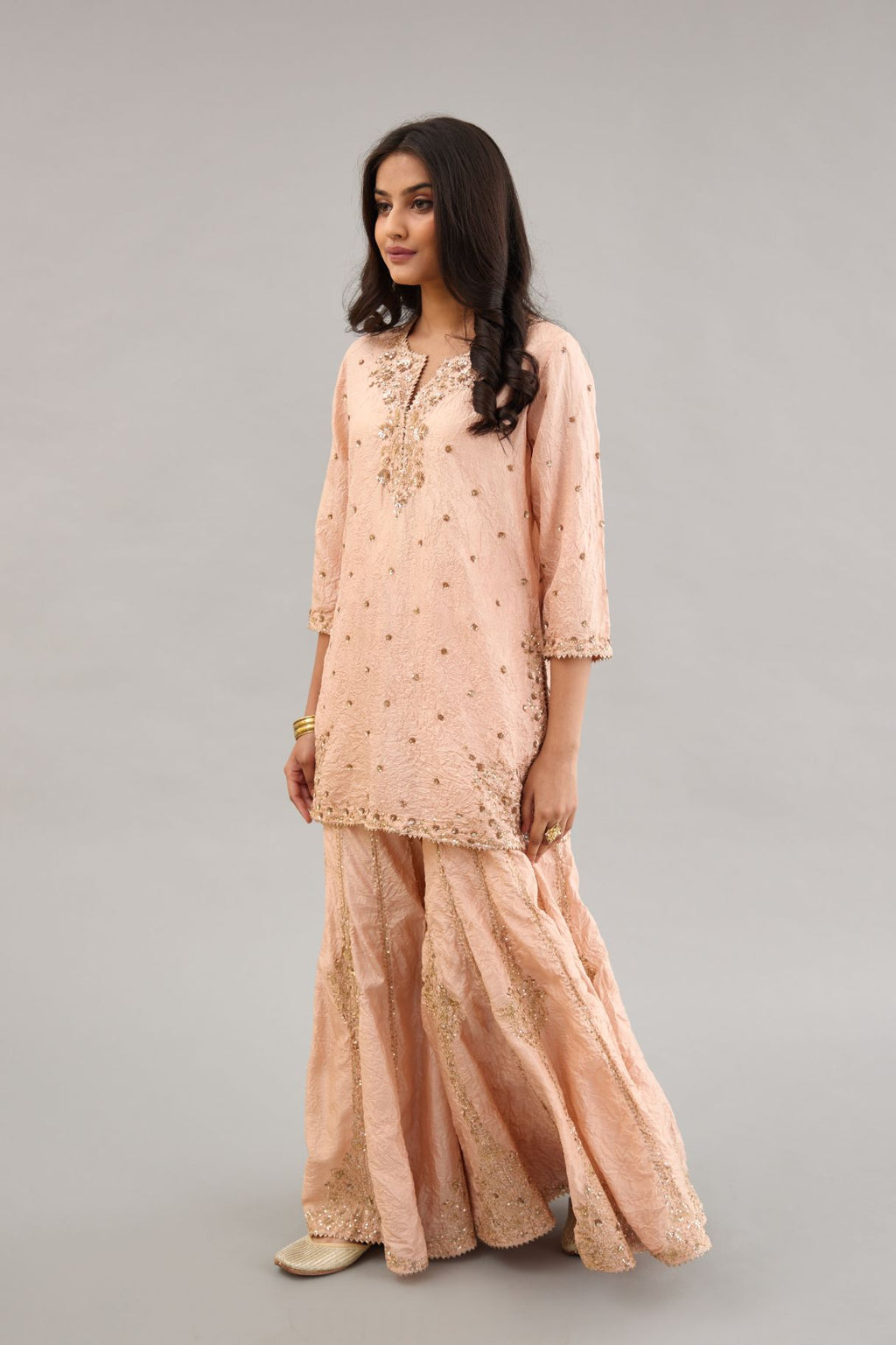 Pink hand crushed silk short kurta set with all-over gold sequins and zari handwork, highlighted with gota lace at edges.