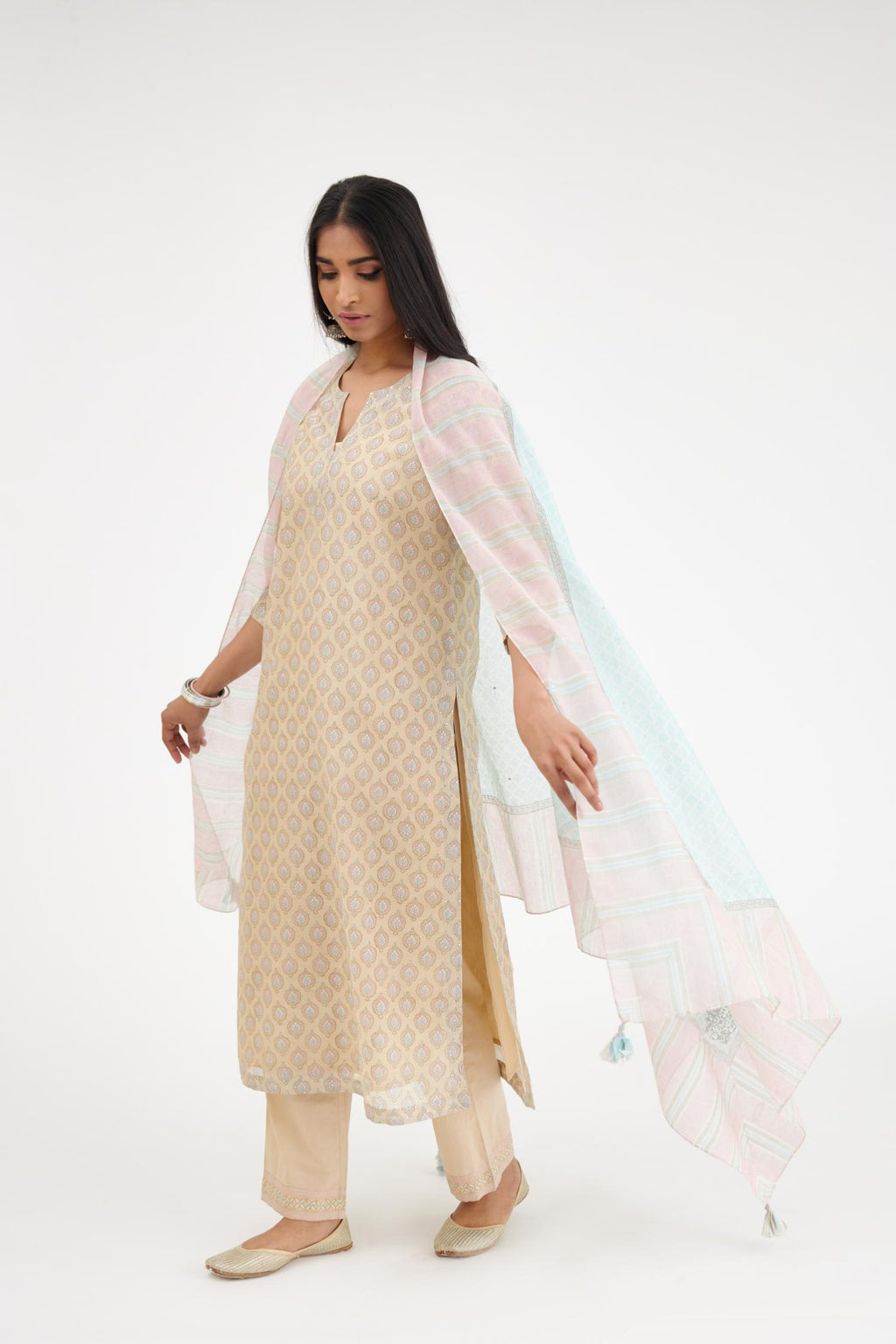 Beige silk Chanderi straight kurta set with all-over hand block print and detailed with silver zari quilting and sequin hand work.