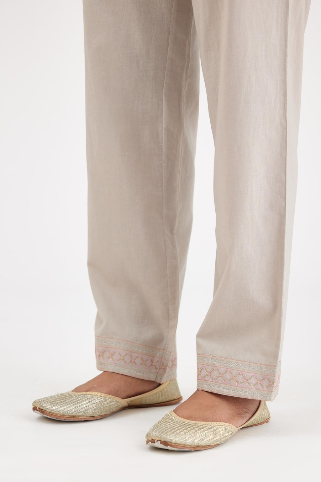Grey cotton straight pants with multi colored thread embroidery, highlighted with silver zari embroidery at bottom hem