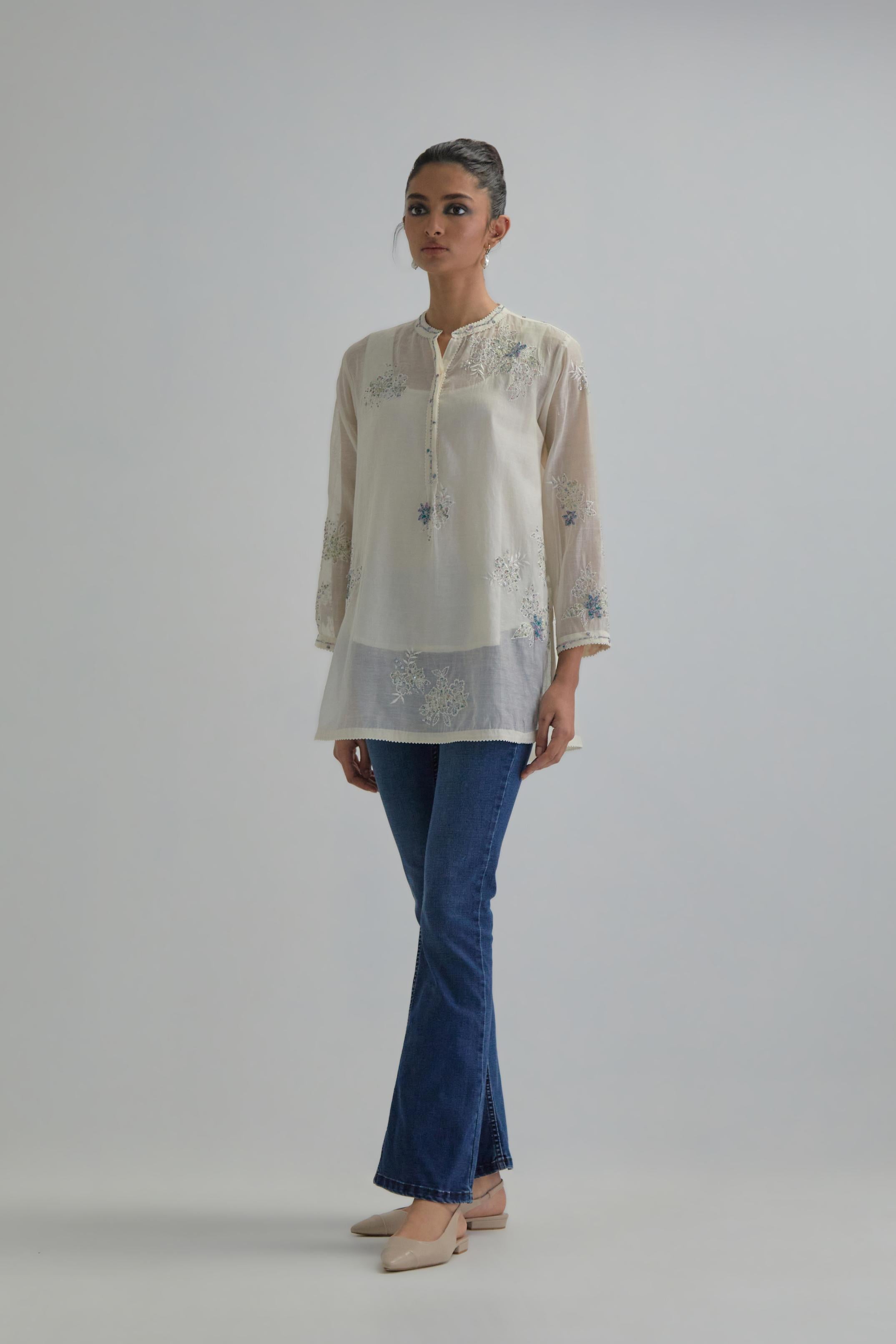 Off white cotton Chanderi top with all-over delicate embroidered blue & beige hand block printed applique flowers, highlighted with sequins and multi coloured beads.