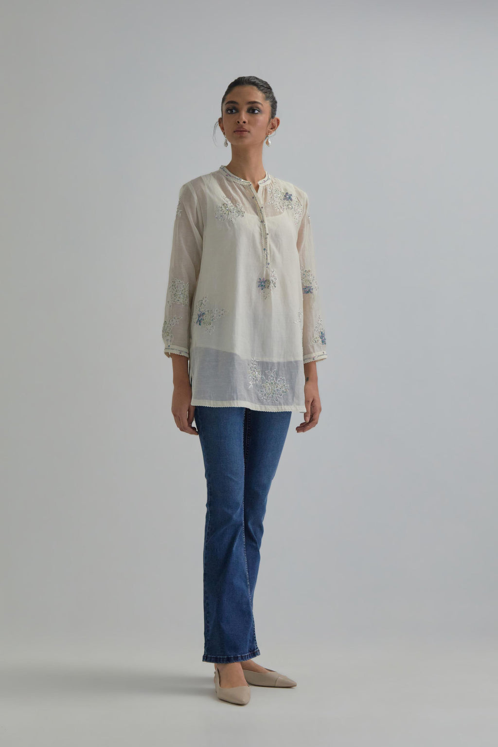 Off white cotton Chanderi top with all-over delicate embroidered blue & beige hand block printed applique flowers, highlighted with sequins and multi coloured beads.