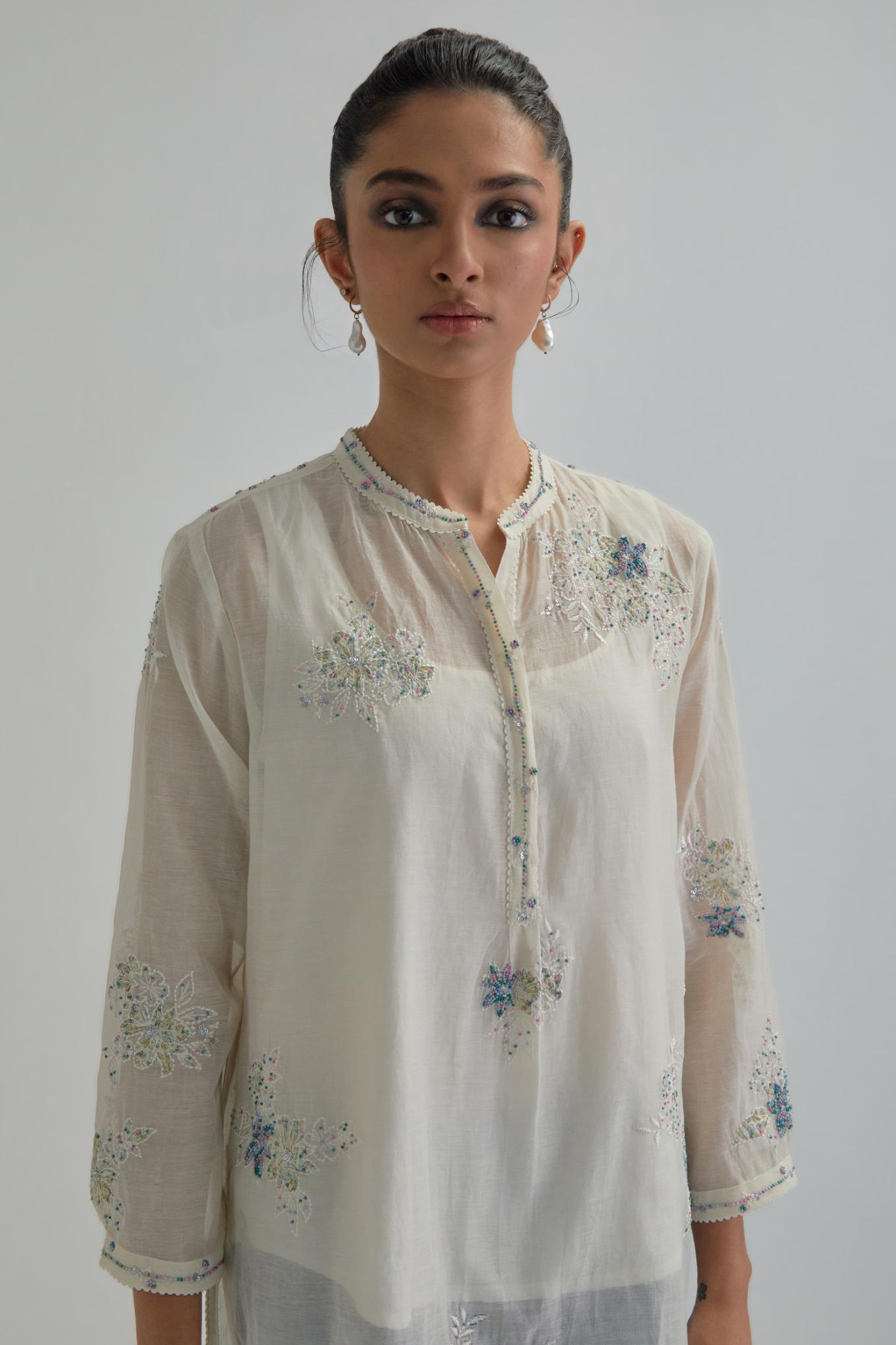 Off white cotton Chanderi top with all-over delicate embroidered blue & beige hand block printed applique flowers, highlighted with sequins and multi coloured beads.