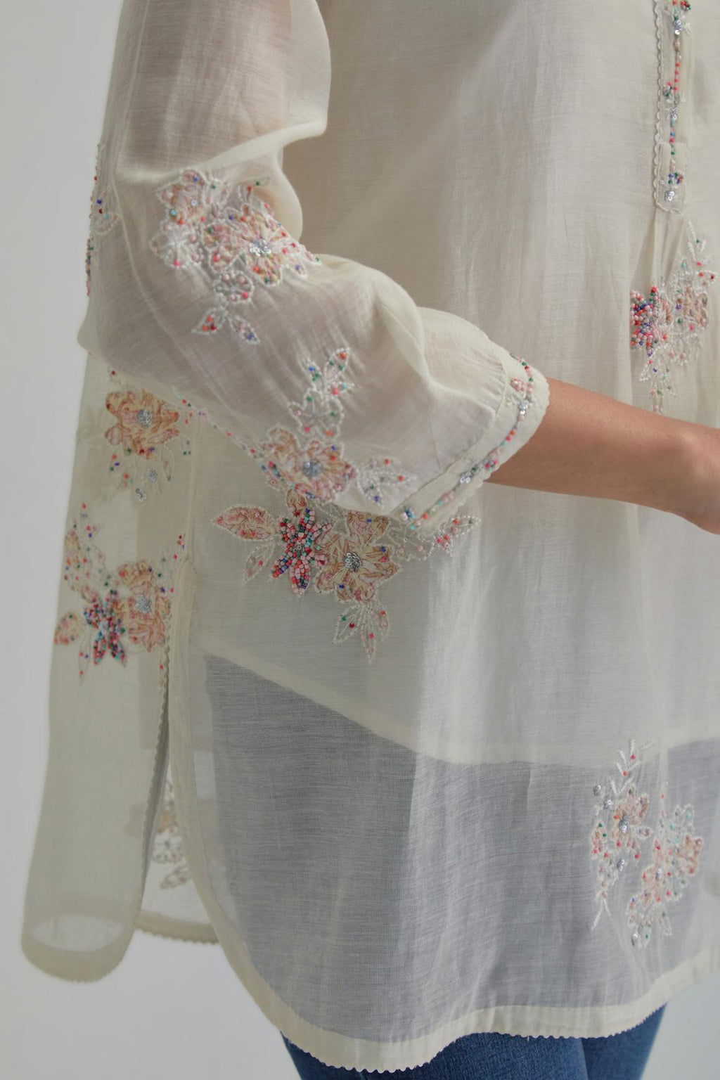 Off white cotton Chanderi top with all-over delicate embroidered pink & beige hand block printed applique flowers, highlighted with sequins and multi coloured beads.