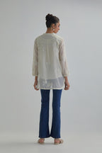 Off white cotton Chanderi top with all-over delicate embroidered applique flowers, highlighted with sequins and beads.