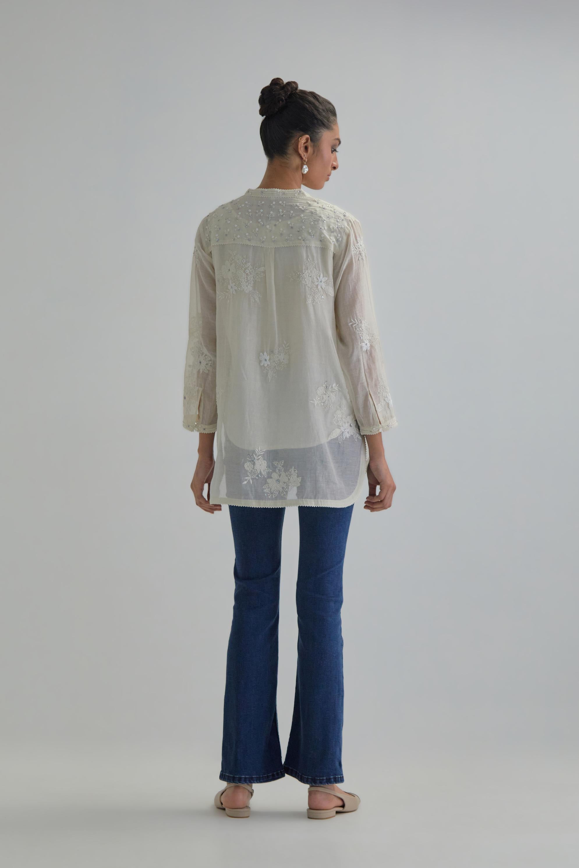 Off white cotton Chanderi top with all-over delicate embroidered applique flowers, highlighted with sequins and beads.