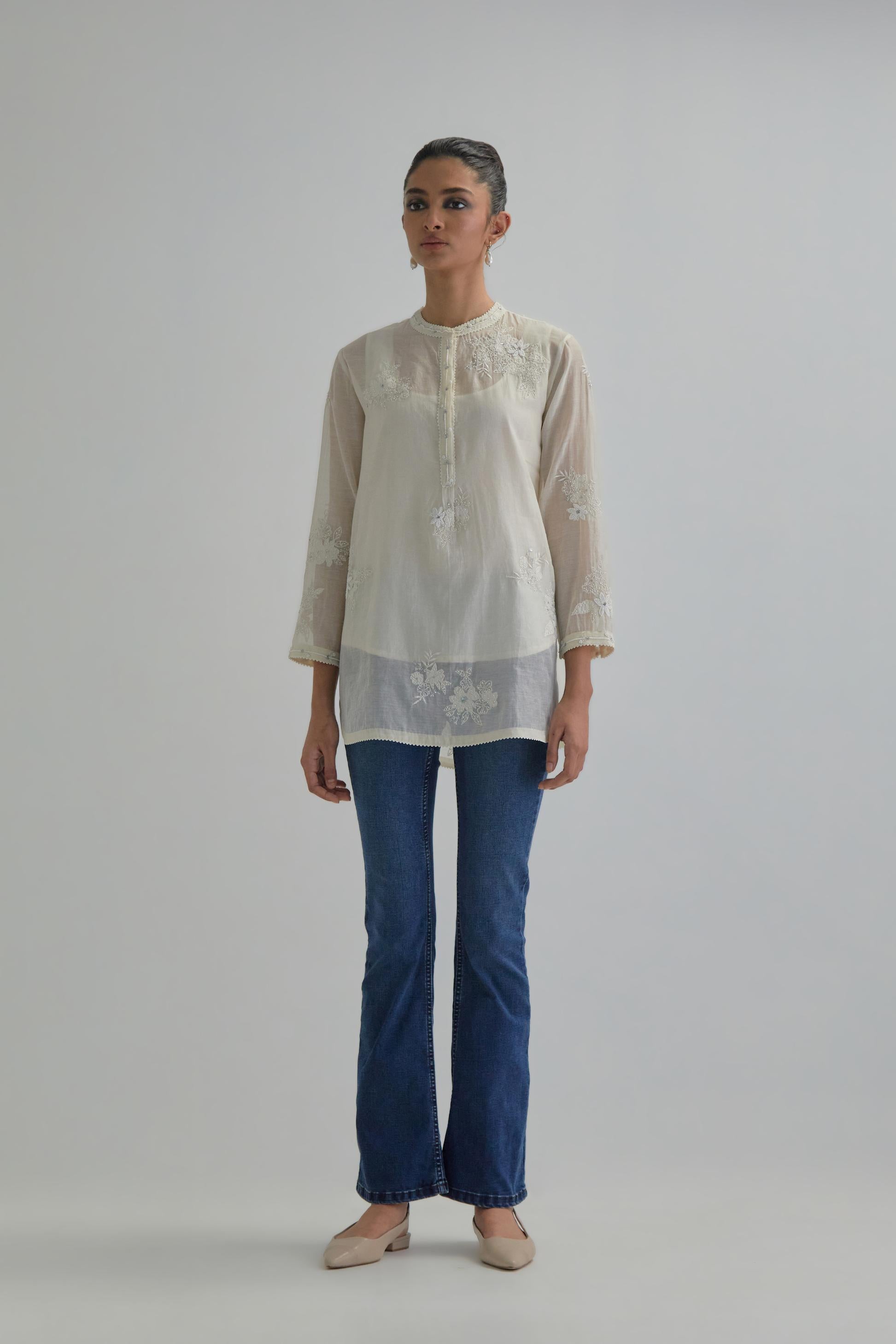 Off white cotton Chanderi top with all-over delicate embroidered applique flowers, highlighted with sequins and beads.