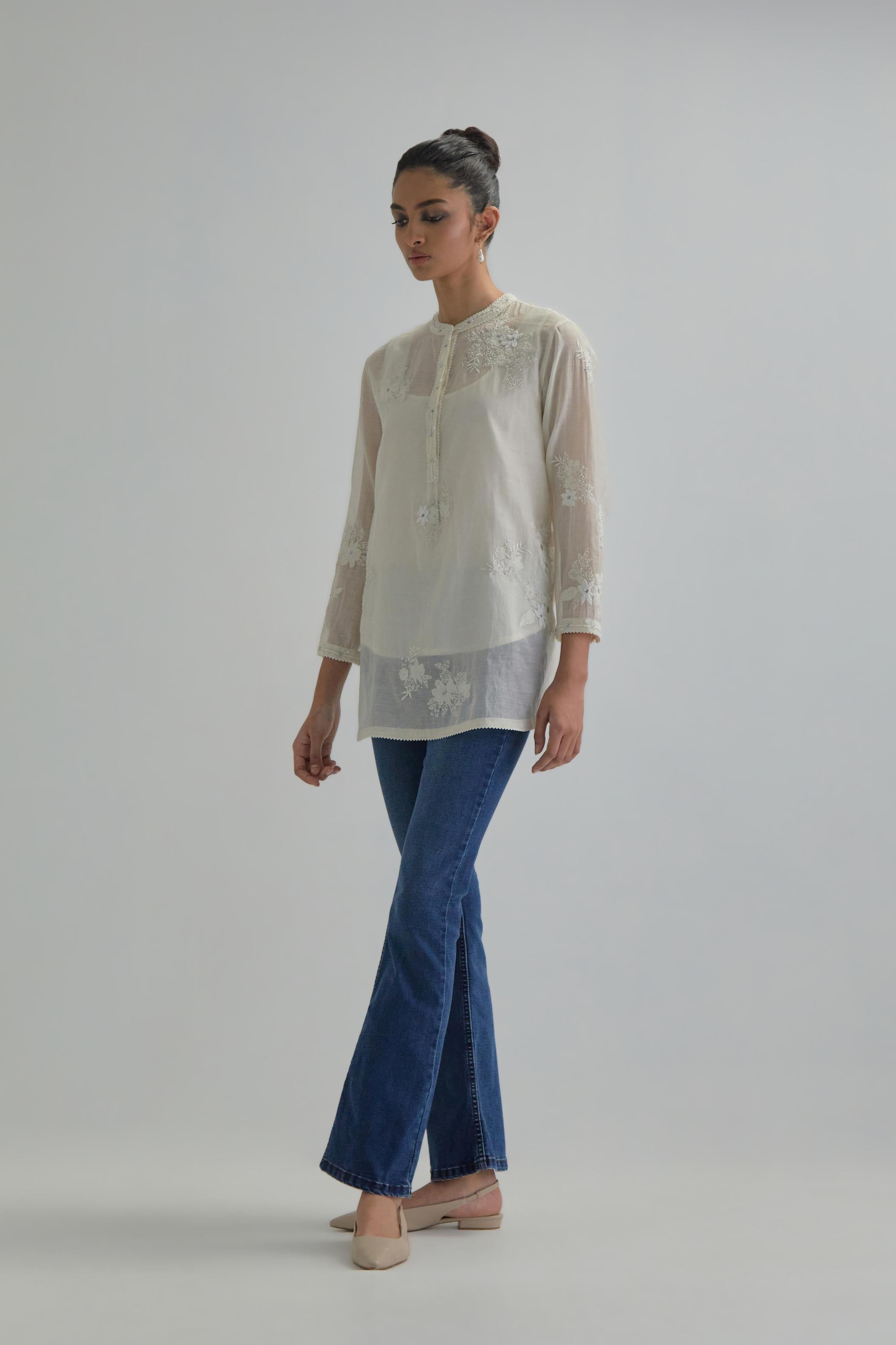 Off white cotton Chanderi top with all-over delicate embroidered applique flowers, highlighted with sequins and beads.