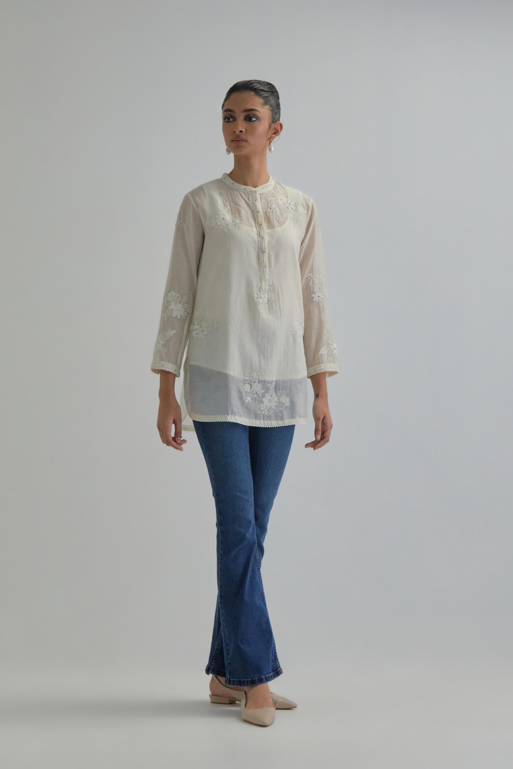 Off white cotton Chanderi top with all-over delicate embroidered applique flowers, highlighted with sequins and beads.