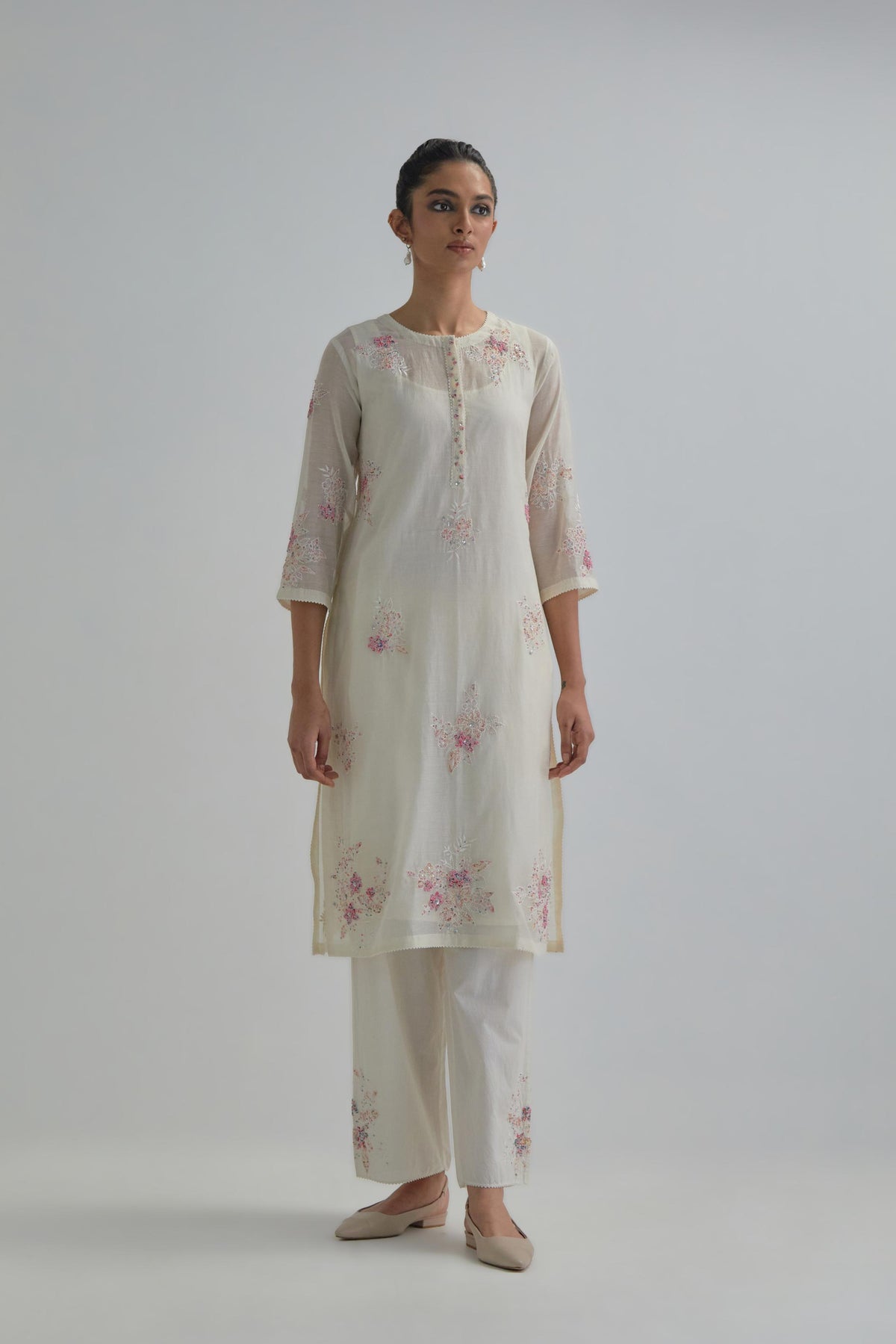Off white straight short kurta set with all-over pink & beige hand block printed appliqué motifs, highlighted with sequins and multi coloured beads.