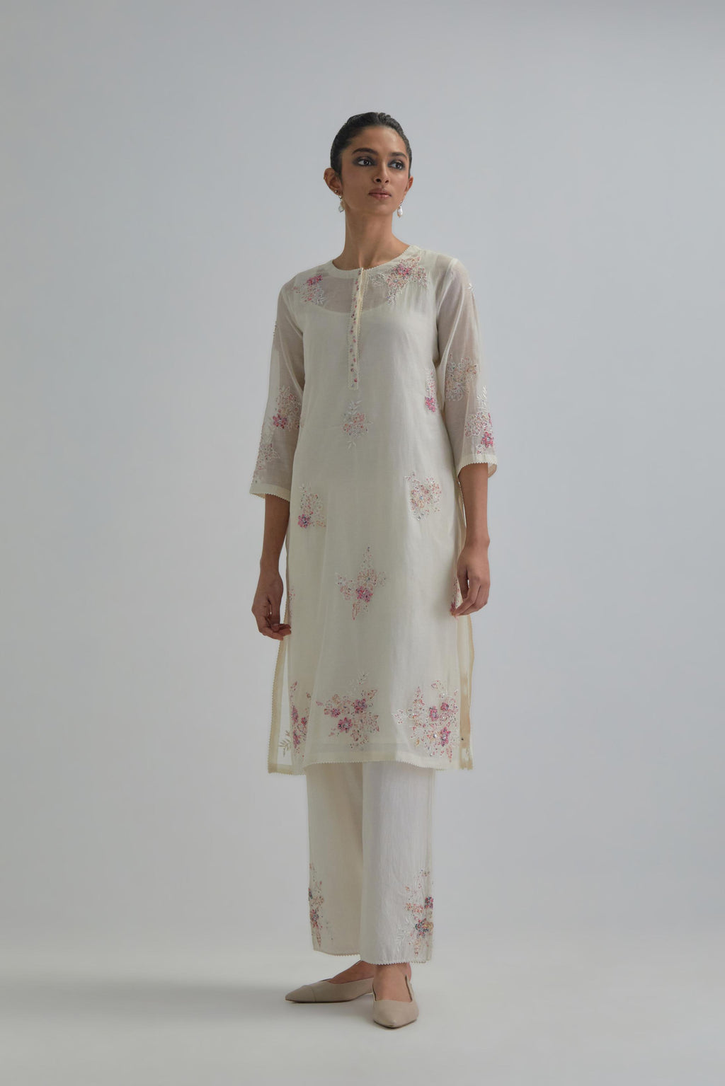Off white straight short kurta set with all-over pink & beige hand block printed appliqué motifs, highlighted with sequins and multi coloured beads.