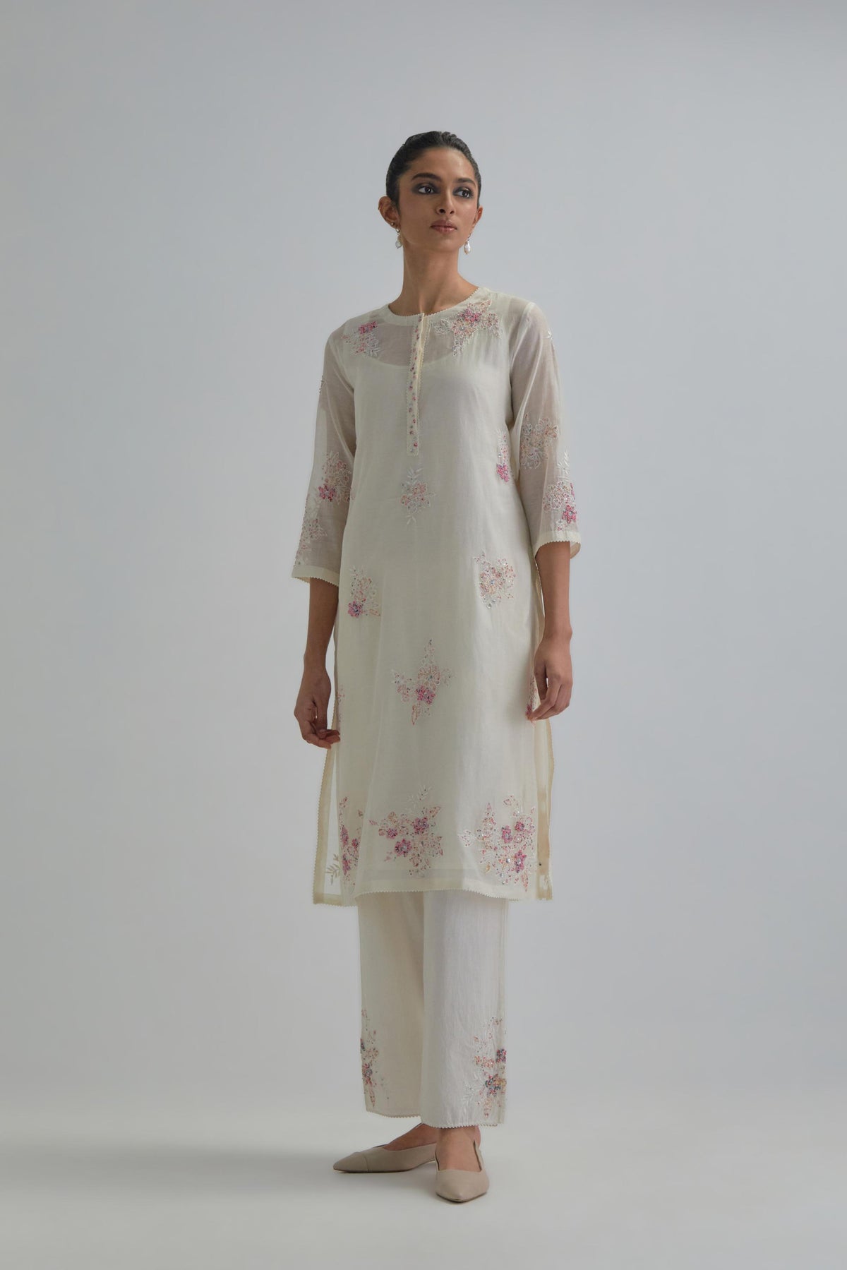 Off white straight short kurta set with all-over pink & beige hand block printed appliqué motifs, highlighted with sequins and multi coloured beads.