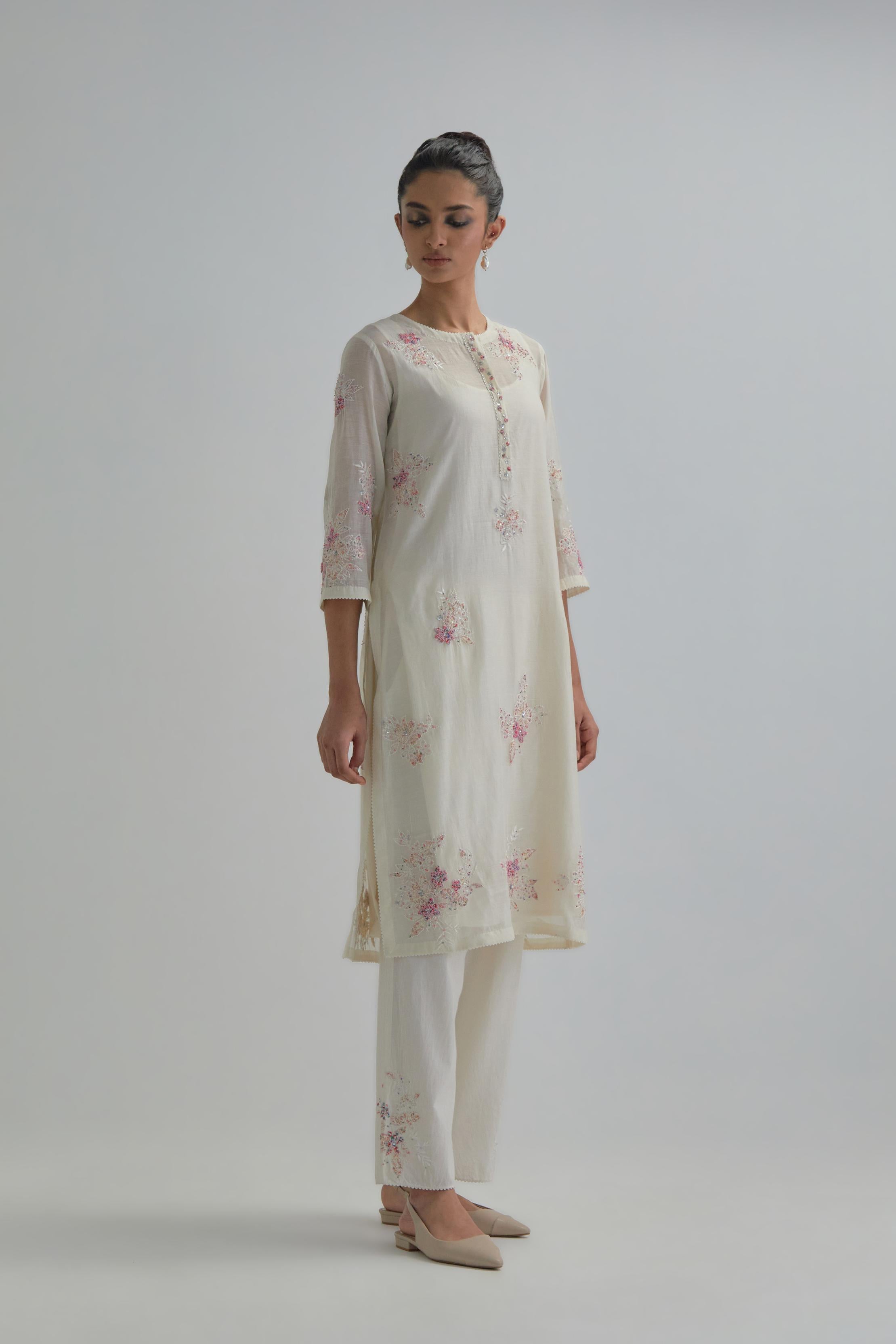 Off white straight short kurta set with all-over pink & beige hand block printed appliqué motifs, highlighted with sequins and multi coloured beads.